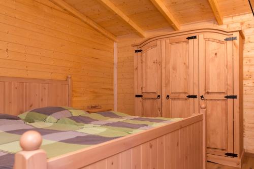 a bedroom with a bed in a wooden cabin at Ferienanlage Markus Nitsch in Bärenstein