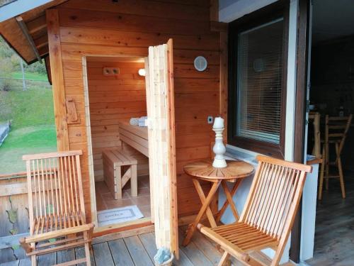 a wooden cabin with two chairs and a table at Apartment KAYA in Mojstrana