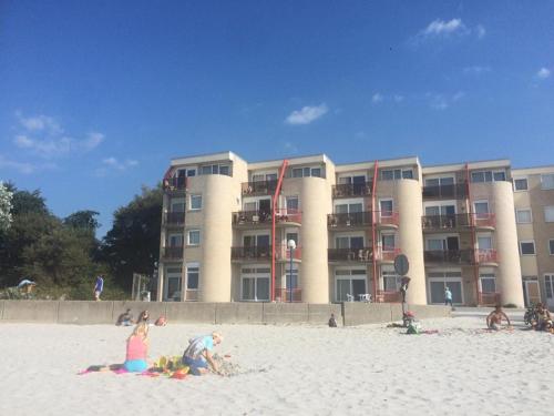 a group of people on the beach in front of a building at Zuiderzeestate 28 in Makkum
