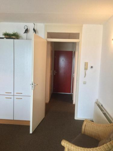 a room with a hallway with a red door at Zuiderzeestate 28 in Makkum