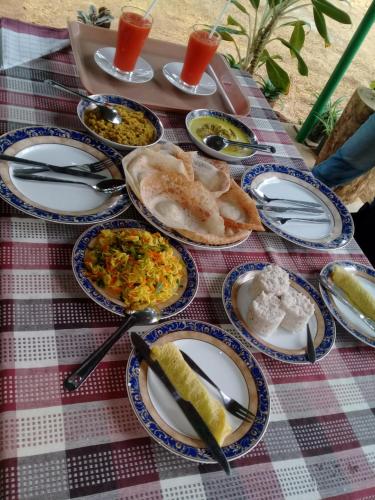 a table with plates of food on a picnic table at Kithmi Resort in Polonnaruwa