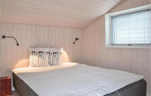 a bedroom with a large white bed with a window at Three-Bedroom Holiday Home In Jagerspris in Jægerspris