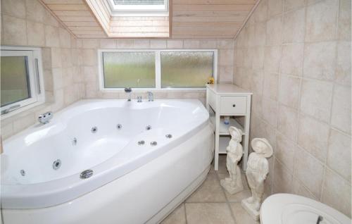 a large white tub in a bathroom with a toilet at Three-Bedroom Holiday Home In Lundby in Lundby