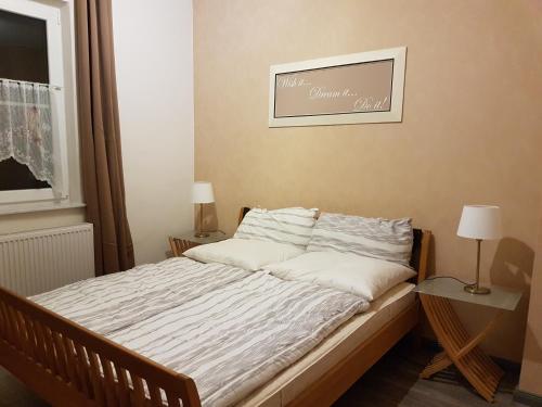 a bed in a bedroom with a picture on the wall at Ferienwohnungen Harz - Wieda in Wieda