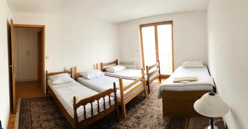 pokój z 3 łóżkami i oknem w obiekcie SARAJEVO-ADI APARTMENTS II w Sarajewie
