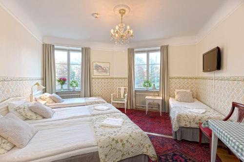 a hotel room with two beds and a chandelier at Wasa Park Hotel in Stockholm