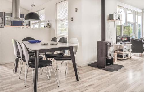 a dining room with a table and chairs and a stove at Holiday Home Strandparken in Otterup