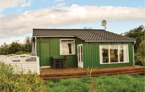 a green tiny house with a wooden deck at Holiday Home Lakolk Xc Denmark in Rømø