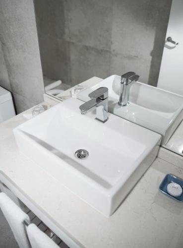 a white sink in a bathroom with a mirror at Kalá Hotel Boutique in Punta del Este