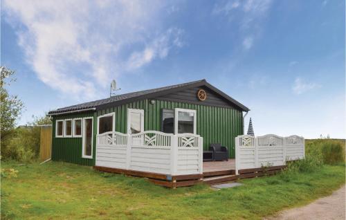 a green and white house with a large deck at Holiday Home Lakolk Xc Denmark in Rømø
