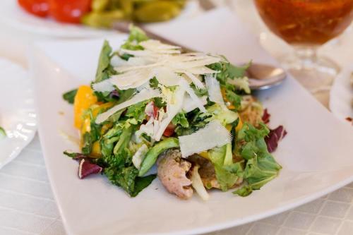 a white plate with a salad on a table at Сьоме небо - The Seventh Heaven in Doroshuv Velikiy