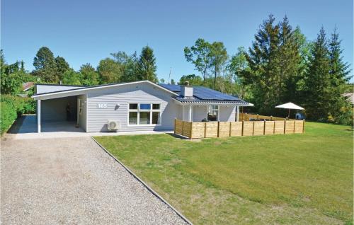 a small white house with a large yard at Four-Bedroom Holiday Home Ebeltoft With A Fireplace 04 in Øksenmølle