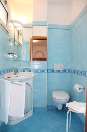 a blue bathroom with a sink and a toilet at Hotel Gran Venere Beach 3s in Bibione