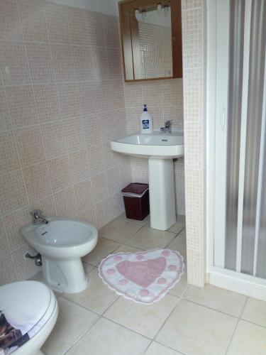 a bathroom with a toilet and a sink at Sa Corte Antiga in Nebida