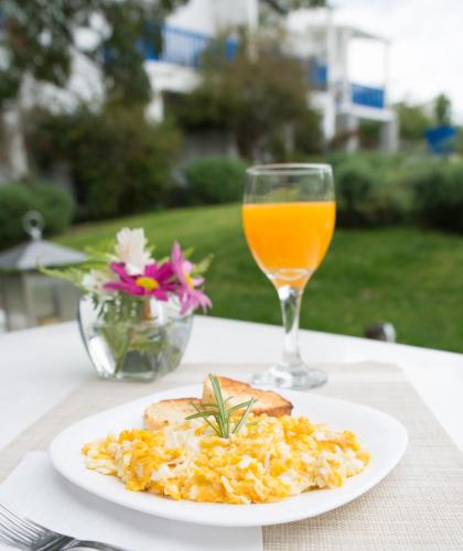 a plate of scrambled eggs and a glass of orange juice at Kalá Hotel Boutique in Punta del Este