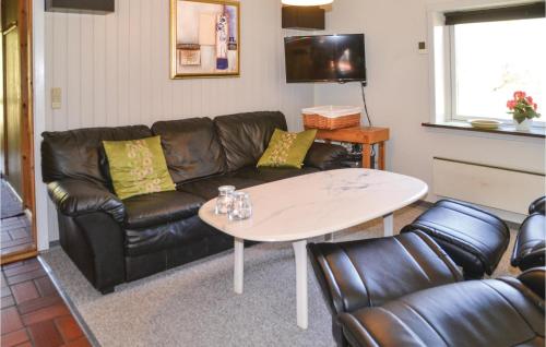 un salon avec un canapé en cuir et une table dans l'établissement Holiday Home Fyrrekrogen Nørre Nebel Vi, à Lønne Hede