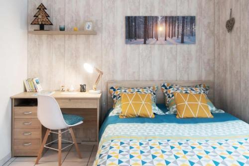 a bedroom with a bed and a desk and a chair at Appart'Confort - Le Scandi-Cosy in Saint-Brieuc