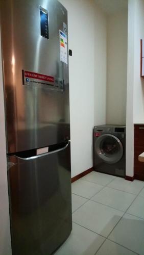 a refrigerator in a kitchen with a washing machine at Les Villas Thorel - Blue P in Rivière Noire