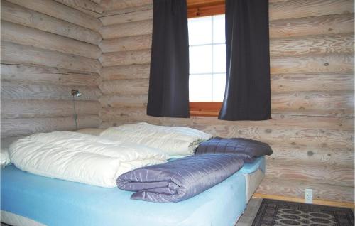 a bed in a log cabin with a window at Holiday Home Enebærvænget in Humble