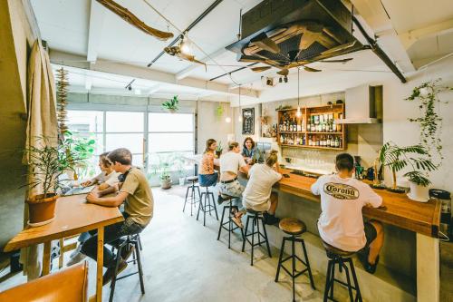 un gruppo di persone seduti al bar di Hippo Hostel and Cafe Bar ad Osaka