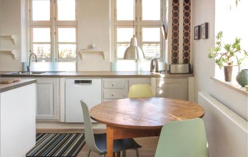 cocina con mesa de madera y sillas verdes en 7 Bedroom Stunning Home In Tranekr, en Skattebølle