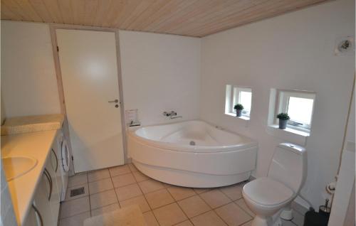 ブロックフスにあるBeautiful Home In Blokhus With Kitchenの白いバスルーム(バスタブ、トイレ付)