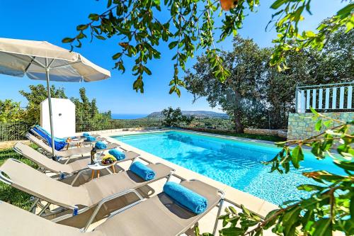 una piscina con tumbonas, una mesa y una piscina en Grand View Villa Private Heated Pool, en Georgioupoli
