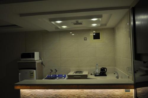 a small kitchen with a sink and a microwave at شقق منازل الدانة للشقق المخدومة in Abha