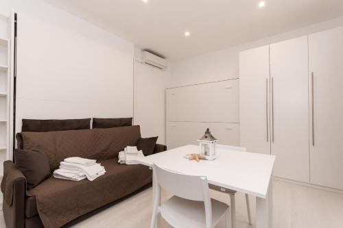 a living room with a couch and a white table at Residence Finale Bike and Beach in Finale Ligure
