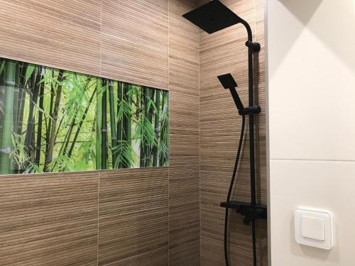 a shower in a bathroom with a window at Płock by day in Płock