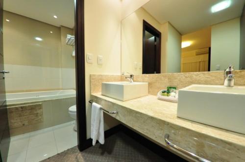 uma casa de banho com um lavatório, um WC e um espelho. em Villa Vergueiro Hotel em Passo Fundo