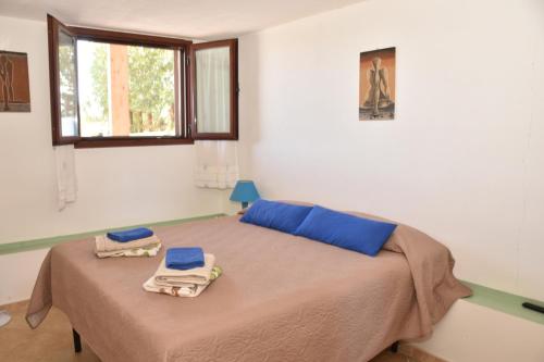a bedroom with a bed with two towels on it at Affittacamere Casa Maica in Stintino