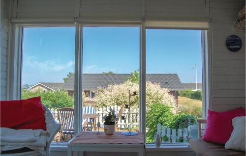 a screened in porch with a table and a window at One-Bedroom Holiday Home In Sjolund in Sjølund
