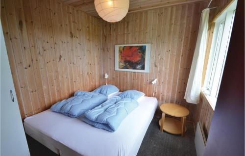 トランにあるNice Home In Lgstr With 3 Bedrooms, Sauna And Wifiの青い枕が付いたベッドが備わる客室です。