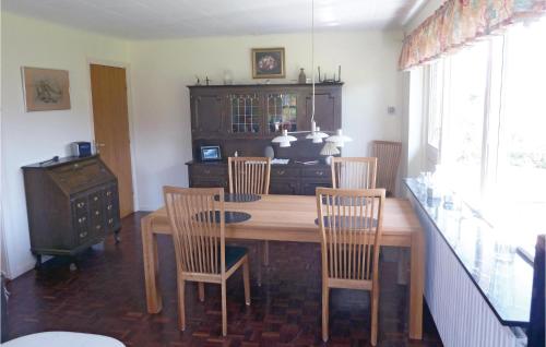 a dining room with a wooden table and chairs at Holiday Home Korsbjerg in Allinge