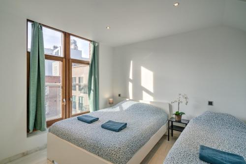 a bedroom with two beds and a window at Marble Lodge Apartments in the Center of Antwerp in Antwerp