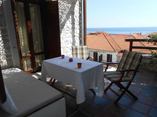 a white table and chairs on a patio with a view at AUTUMN TO SUMMER in Agios Ioannis Pelio