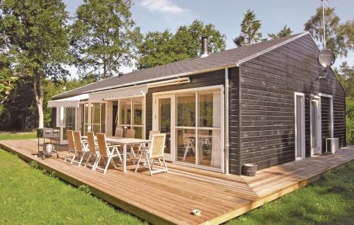 a tiny house with a deck with a table and chairs at Holiday Home Sahara Rønne I in Rønne