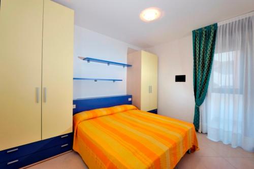 ビビオーネにあるResidence Geminiのベッドルーム1室(黄色と青のベッド1台、窓付)