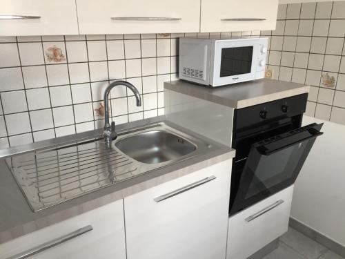 Miggianoにあるcasa-zinoのシンクと電子レンジ付きのキッチン