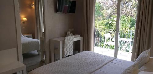 a bedroom with a bed and a window with a balcony at Borgo di Santa Barbara in Santa Domenica