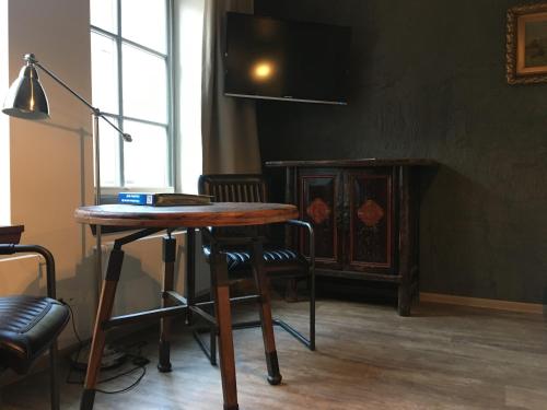 a table and chairs in a room with a television at Hugos Haus & Berthas Haus in Eckernförde