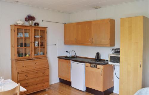 a kitchen with wooden cabinets and a counter top at Apartment Kystvej Hornbæk Ii in Hornbæk