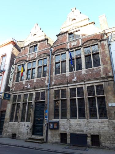 a brick building with a clock on the front of it at Erasmus Hotel in Ghent