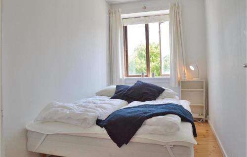 uma cama num quarto branco com uma janela em 1 Bedroom Cozy Apartment In Hornbk em Hornbæk