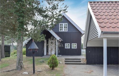 a black house with a gate in front of it at Two-Bedroom Holiday Home In Ebeltoft in Ebeltoft