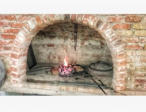 a brick oven with a fire in it at Konak Umoljani in Umoljani