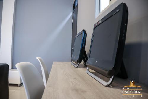 two computer monitors sitting on top of a table at HOTEL ESCORIAL PITALITO in Pitalito