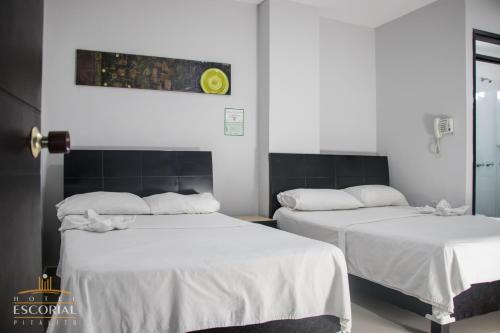皮塔利托HOTEL ESCORIAL PITALITO的配有白色床单的客房内的两张床