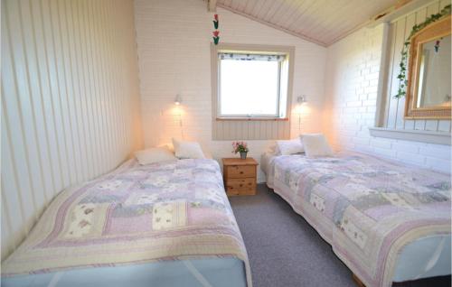 a bedroom with two beds and a window at Holiday Home Hvide Sande With A Fireplace 01 in Bjerregård